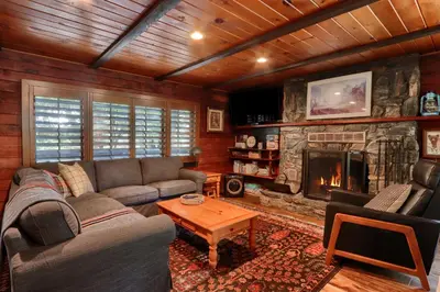 a living room with a couch and a fireplace at The Overlook in Wawona
