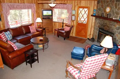 a living room with leather furniture and a fireplace at Manzanita Lodge in Wawona