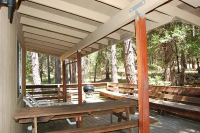 a porch with a picnic table and a grill at Altitude Adjustment in Wawona