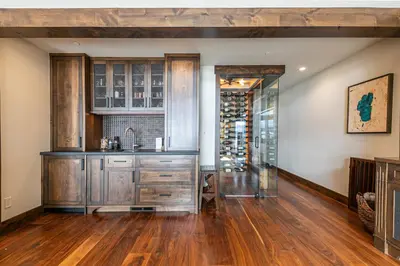 a kitchen with wooden cabinets and a wine cellar at Aqua Vista Lakefront Estate by Tahoe Getaways - 6 BR in Carnelian Bay w Buoy, Pier & Game Room in Carnelian Bay
