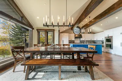 a dining room and kitchen with a large wooden table at Aqua Vista Lakefront Estate by Tahoe Getaways - 6 BR in Carnelian Bay w Buoy, Pier & Game Room in Carnelian Bay