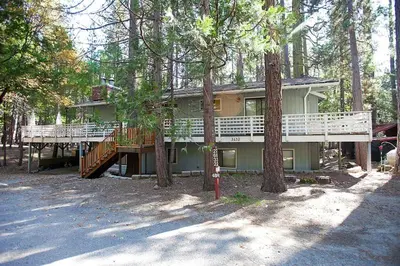 a large house with a deck in the trees at The Tree House II in Wawona