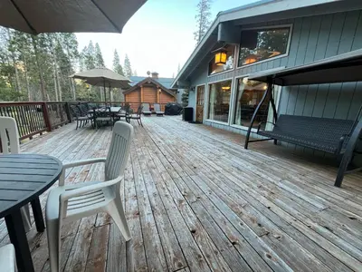 a wooden deck with tables and chairs on a house at The Tree House II in Wawona