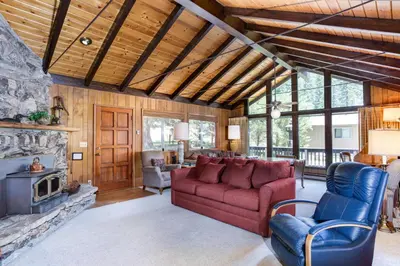 a living room with a red couch and a fireplace at Mountain Memory in Wawona
