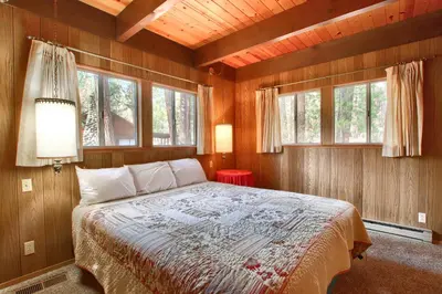 a bedroom with a bed in a room with windows at Spindler's Chalet in Wawona