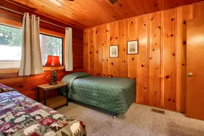a bedroom with a bed in a wooden cabin at Deer Creek in Wawona