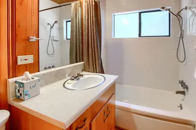 a bathroom with a sink and a toilet and a window at Deer Creek in Wawona
