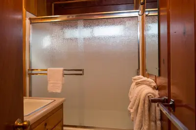 a glass shower in a bathroom with a sink at Hansen Cabin in Wawona