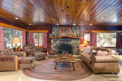 a living room with a stone fireplace in a house at Hansen Cabin in Wawona