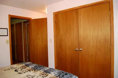 a bedroom with a bed and a wooden closet at Edmond's Place in Wawona