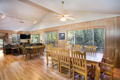 a dining room and living room with a table and chairs at River Lodge in Wawona