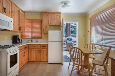 a kitchen with a white refrigerator and a table at Sparrow's Nest in Wawona