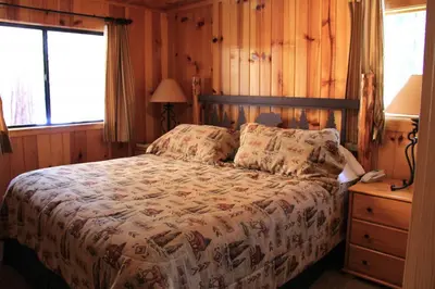a bedroom with a bed and a wooden wall at Grizzly Giant in Wawona