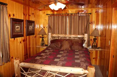 a bedroom with a bed in a log cabin at Grizzly Giant in Wawona