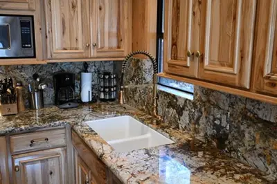 a kitchen with a white sink and wooden cabinets at Grizzly Giant in Wawona