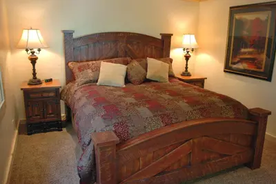 a bedroom with a large wooden bed with two lamps at El Capitan in Wawona