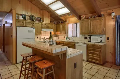 a kitchen with wooden cabinets and a counter with stools at Bordentown West in Wawona