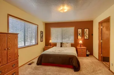 a bedroom with a bed and two dressers and two windows at Bordentown West in Wawona