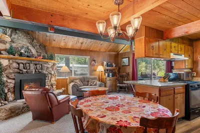 a kitchen and living room with a table and a fireplace at Meadow View in Wawona