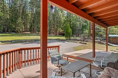 a screened porch with chairs and a table and a table at Meadow View in Wawona