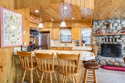 a kitchen with a table and chairs and a fireplace at Cedar Lodge in Wawona
