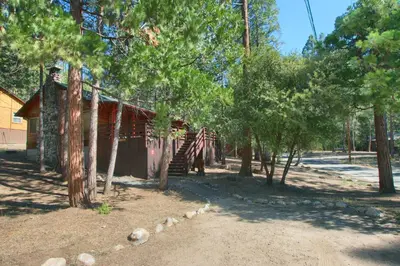 a log cabin with trees in front of it at Simmons Den in Wawona