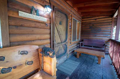 a porch of a wooden cabin with a bench at Howard's Retreat in Wawona