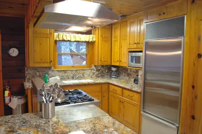 a kitchen with wooden cabinets and a stainless steel refrigerator at Half Dome in Wawona