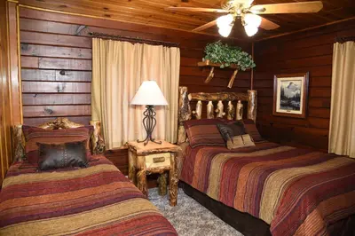 a bedroom with two beds and a ceiling fan at Half Dome in Wawona