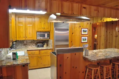 a kitchen with wooden cabinets and a stainless steel refrigerator at Half Dome in Wawona