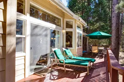 a screened in porch with chairs and an umbrella at Miller's Landing in Wawona
