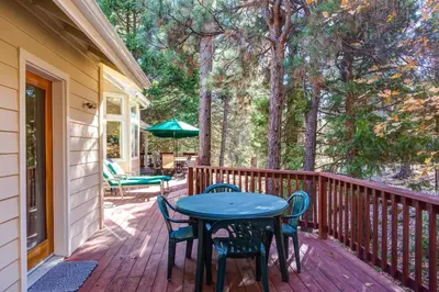 a patio with a table and chairs on a deck at Miller's Landing in Wawona