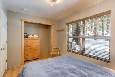 a bedroom with a bed and a dresser and a window at Wawona Chalet in Wawona