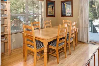 a wooden dining room table with chairs and a window at Wawona Chalet in Wawona