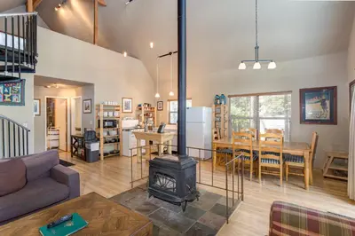 a living room with a stove and a dining room at Wawona Chalet in Wawona