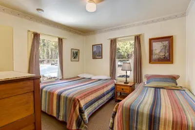 a bedroom with two beds and a window at Chatterton's Cottage in Wawona