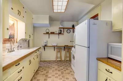 a kitchen with a white refrigerator and a sink at Chatterton's Cottage in Wawona