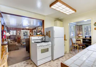 a kitchen with a stove and a refrigerator at Chatterton's Cottage in Wawona