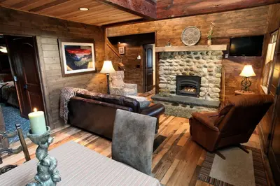 a living room with a couch and a fireplace at Boot's Haven in Wawona