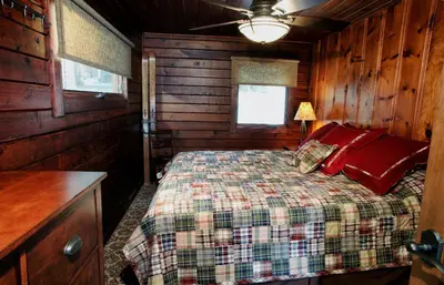 a bedroom with a bed in a wooden cabin at Boot's Haven in Wawona