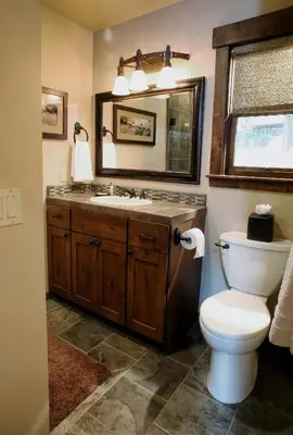 a bathroom with a toilet and a sink and a mirror at Boot's Haven in Wawona