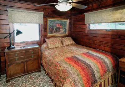 a bedroom with a bed and a dresser and a window at Boot's Haven in Wawona