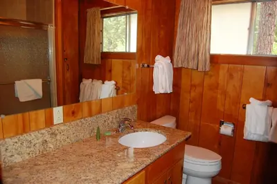 a bathroom with a sink and a toilet and a mirror at Harmony Villa in Wawona