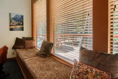 a room with a couch in front of a window at Jolie Cabin in Wawona