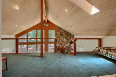 a large room with a bed and a large window at Jolie Cabin in Wawona
