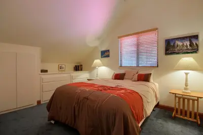 a bedroom with a large bed and a window at Jolie Cabin in Wawona