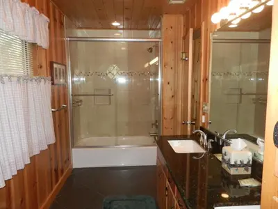 a bathroom with a shower and a sink and a tub at Deer Lodge in Wawona