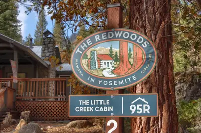 a sign for a tree red woods in yosemite at The Little Creek Cabin in Wawona