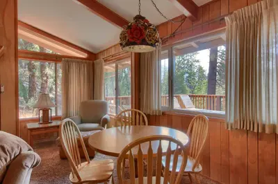 a living room with a table and chairs and a couch at Yosemite Mountain Lodge in Wawona