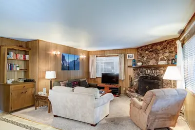 a living room with a couch and a fireplace at Deer Hollow in Wawona